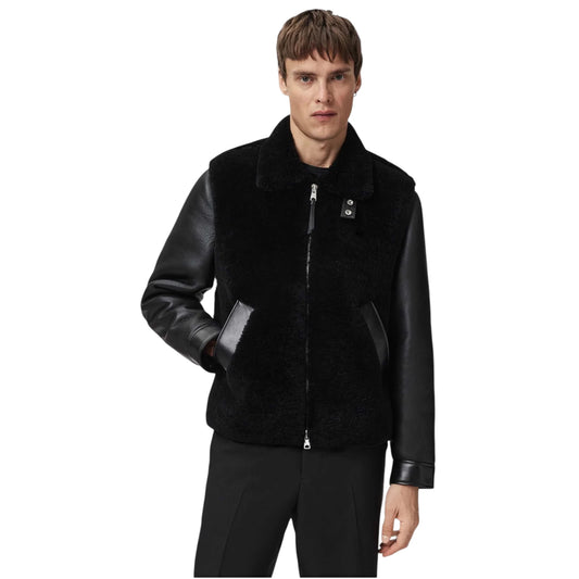 Man wearing a black leather and fur jacket on a white background