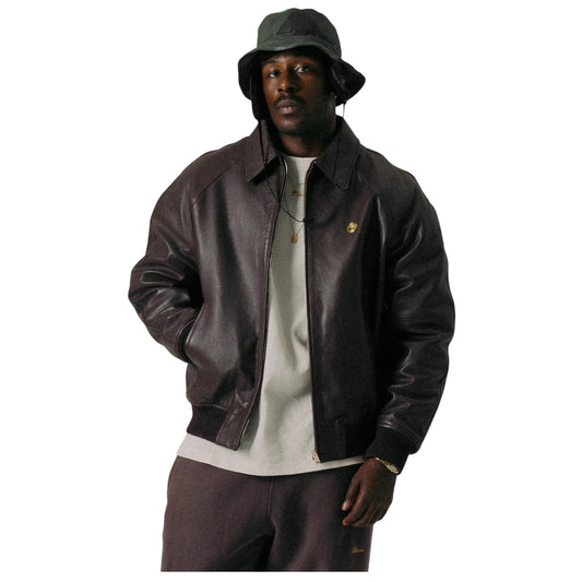 Man wearing a brown leather jacket and hat on a white background
